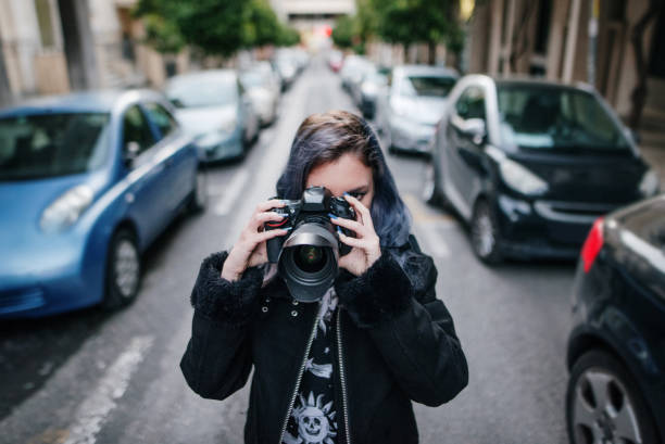 istock Young woman using a DSLR camera in a city 1139962313