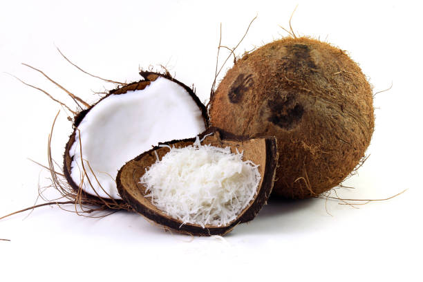 świeże płatki kokosowe umieszczone w korze i skorupie wyizolowane na białym tle. widok z przodu - powdered coconut zdjęcia i obrazy z banku zdjęć