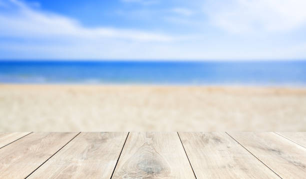istock wooden table top with blur ocean background summer concept - Image 1139972244