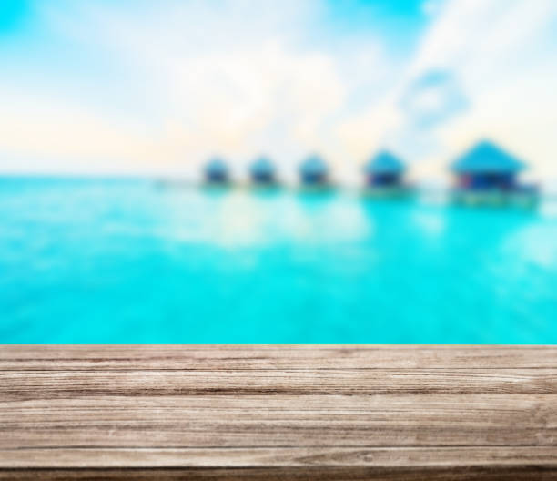 istock wooden table top with blur ocean background summer concept - Image 1139972536