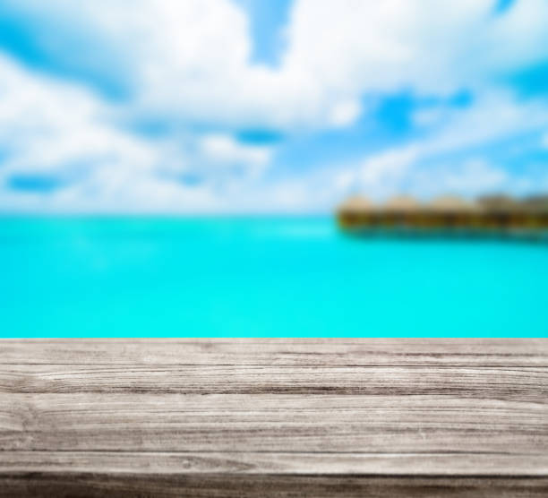 istock wooden table top with blur ocean background summer concept - Image 1139972696