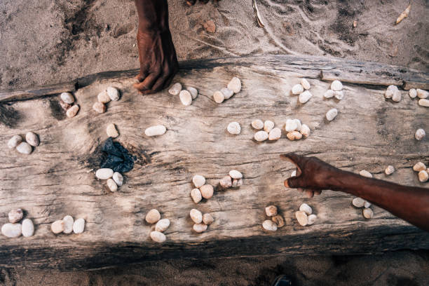 hands playing mancala game which is very popular in africa - thumb stones imagens e fotografias de stock