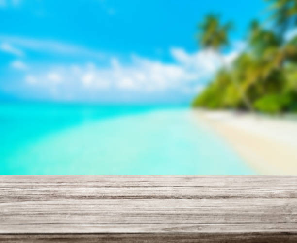 istock wooden table top with blur ocean background summer concept - Image 1139972778
