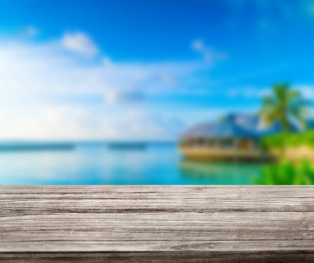 istock wooden table top with blur ocean background summer concept - Image 1139973103