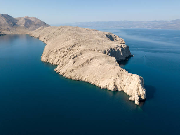 istock Rocky peninsula in blue sea 1139974342