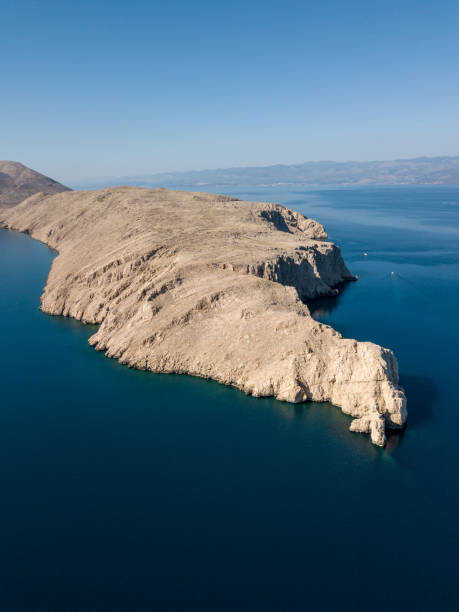istock Rocky peninsula in blue sea 1139974359
