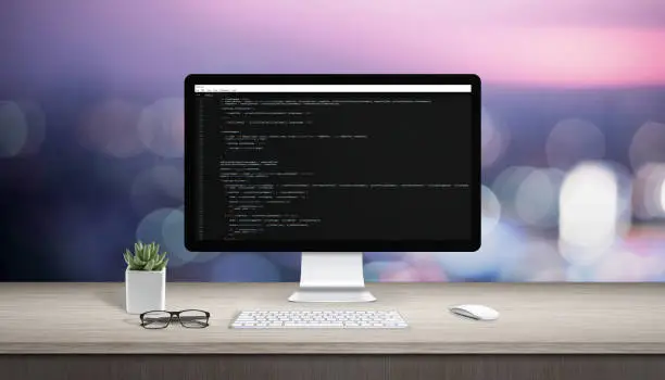 Concept of programming on a computer. Work desk with computer display and text editor.