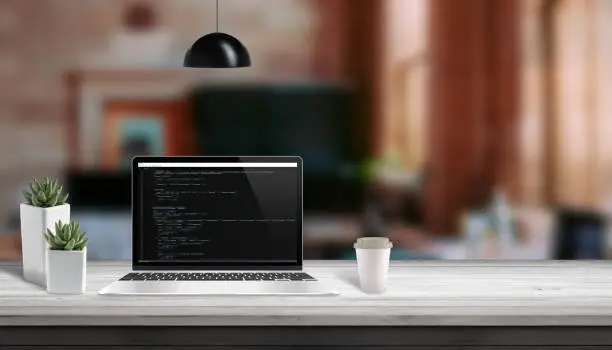 Web development studio concept. Laptop vith script code editor. Copy space beside.