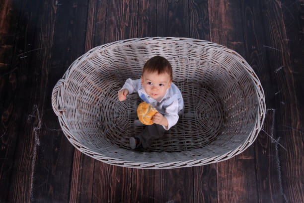 istock A tiny child eats a dry bun in a basket woven from a wicker tree. 1139978380