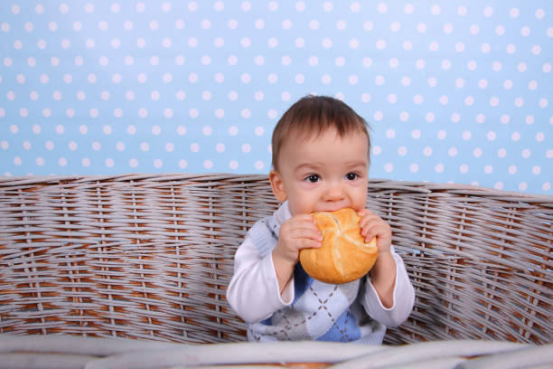 istock A tiny child eats a dry bun in a basket woven from a wicker tree. 1139978478
