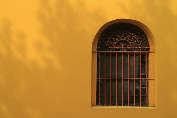istock Red wrought iron decorated window on vivid yellow outer wall, La Boca, Buenos Aires, Argentina 1139979385
