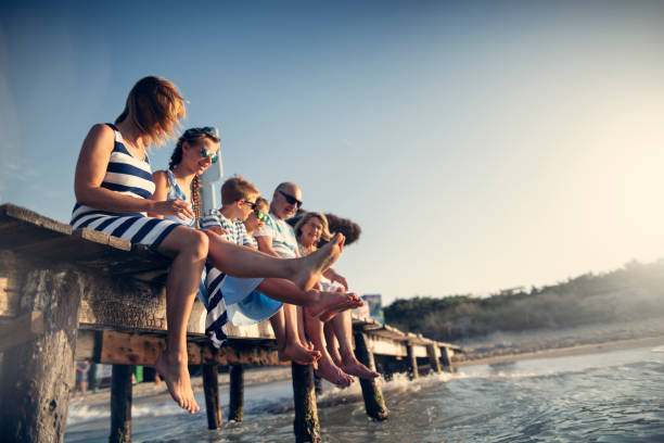 Multi generation family enjoying summer vacations Grandparents and grandchildren enjoying summer vacations. They are sitting on pier, holding hands and cheering.
Sunny summer day evening.
Nikon D850 floating dock stock pictures, royalty-free photos & images