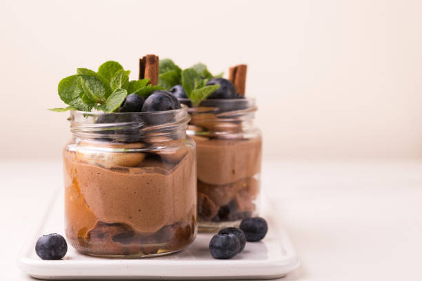 Cake dessert. Chocolate mousse with blueberry, mint and cinnamon Homemade cake dessert. Chocolate mousse with blueberry, mint and cinnamon in glass jars. cake jar stock pictures, royalty-free photos & images