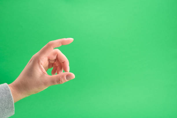 istock female hand on a green background 1139989072