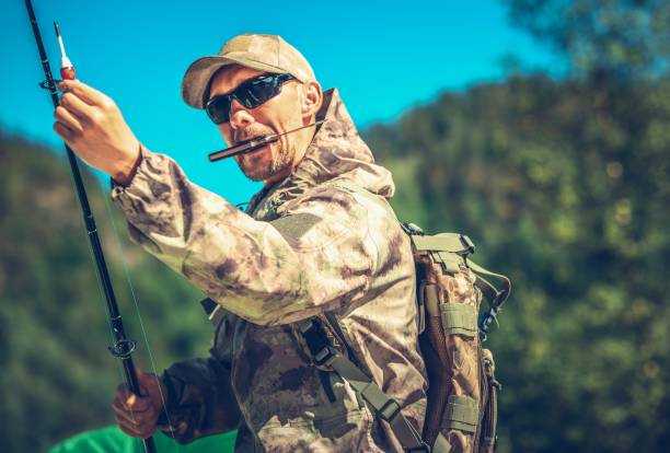 Caucasian Fisherman in His 30s with Knife in Mouth Preparing For a Fly Fishing.
