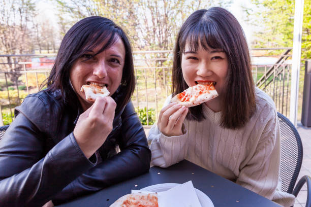 istock young girlfriends females eating 1140003804