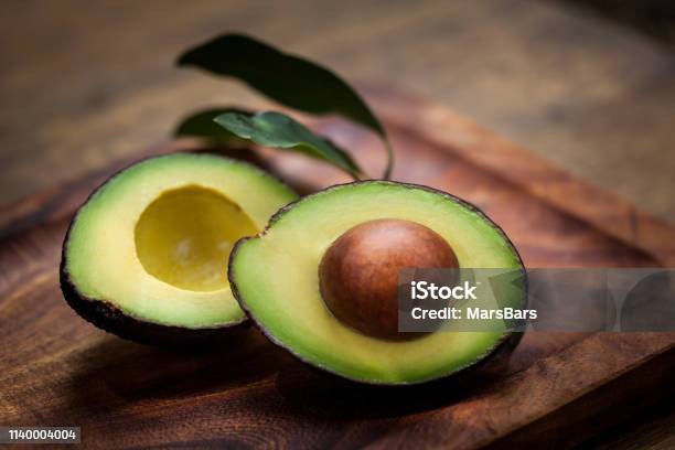 Avocado Halves On A Wooden Board Stock Photo - Download Image Now - Avocado, Fruit, Mexico