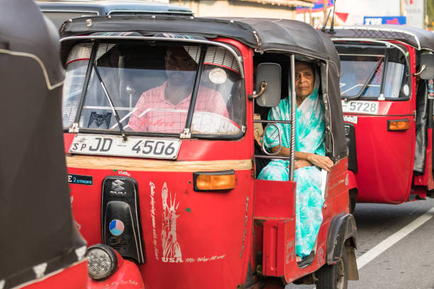 eine lokale sklorenfrau, die an bord der matara road in galle, sri lanka, sitzt. - sri lanka jinrikisha rickshaw tricycle stock-fotos und bilder