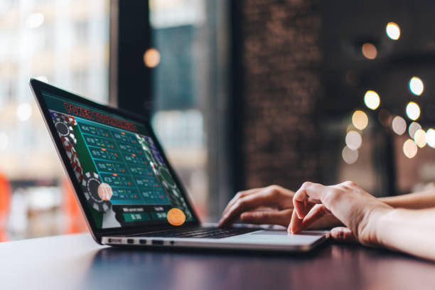 Girl using her laptop for taking part in online poker tournament Close up cropped photo of girl hands using her laptop for taking part in online poker tournament. sports betting stock pictures, royalty-free photos & images