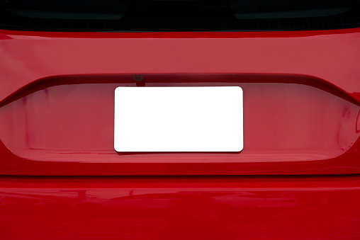 Horizontal shot of a blank white license plate on the back of red car.