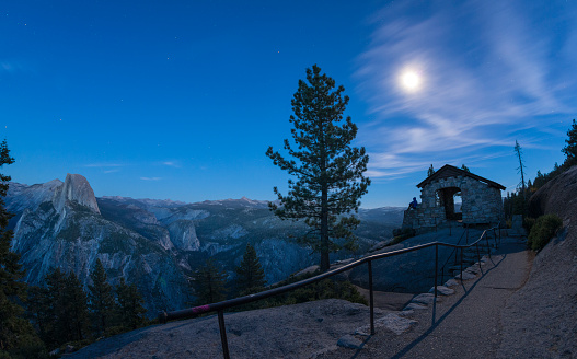 Woman looking at Yosemite Valley from Glacier Point. Half Dome on the background in full moon.
