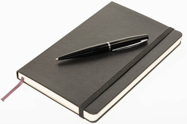 Moleskin Black leather notebook with pen isolated on a white background. moleskin stock pictures, royalty-free photos & images
