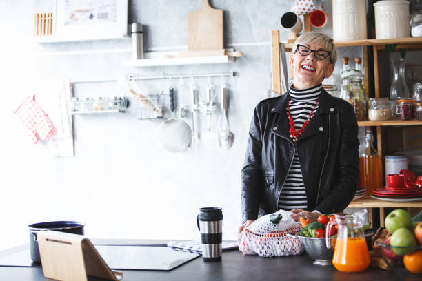 istock Smiling woman in the kitchen after shopping 1140015550