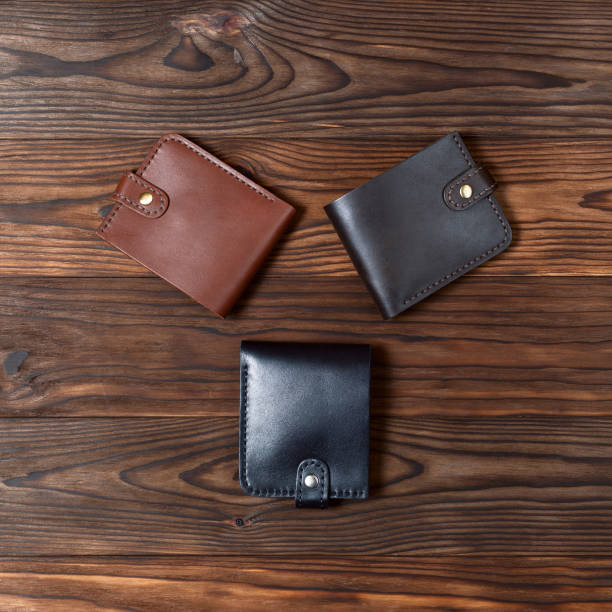 istock Three handmade leather gloss wallets on wooden textured background. Up to down view. Businessman wallet stock photo. 1140017066