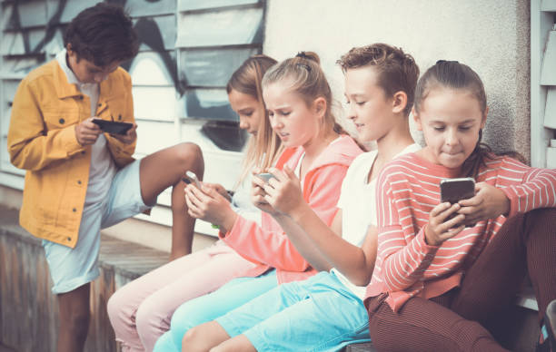 istock Children playing on smartphone outdoors 1140018699