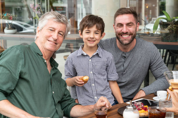 Portrait of three male generations enjoying a breakfast at a restaurant while facing camera smiling very happy