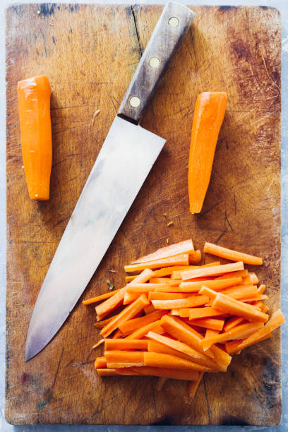 istock Carrot sticks, cut on a cutboard with a big knfe, ready to be prepared as typical italian 