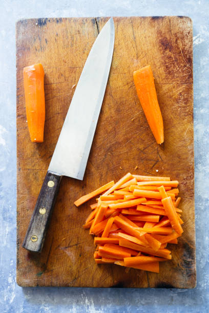 istock Carrot sticks, cut on a cutboard with a big knfe, ready to be prepared as typical italian 