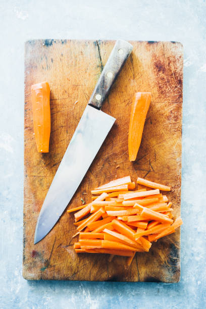 istock Carrot sticks, cut on a cutboard with a big knfe, ready to be prepared as typical italian 