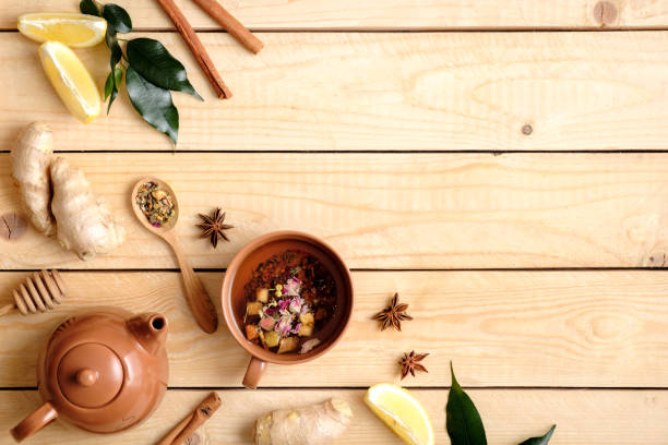 istock Autumn composition with fruit tea cup, teapot, autumn leaves, cinnamon sticks, anise star, spoon of dried team, lemon, ginger root, honey. Top view, flat lay 1140021236