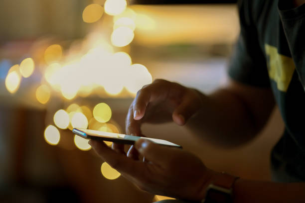 istock Man using his cellphone in walking street and  bokeh lights 1140022752