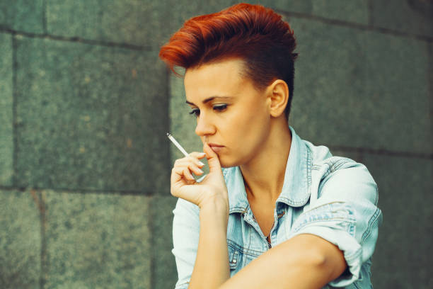 Sad punk woman smoking a cigarette Sad punk woman smoking a cigarette sad gay stock pictures, royalty-free photos & images