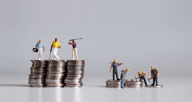 miniaturmenschen, die auf einem haufen münzen stehen. ein begriff der einkommensungleichheit. - uneven stock-fotos und bilder