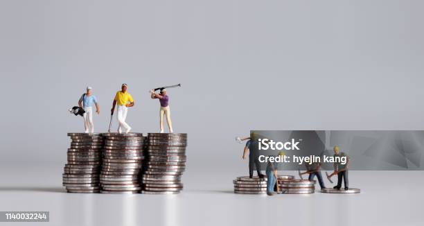 Miniature People Standing On A Pile Of Coins A Concept Of Income Disparity Stock Photo - Download Image Now