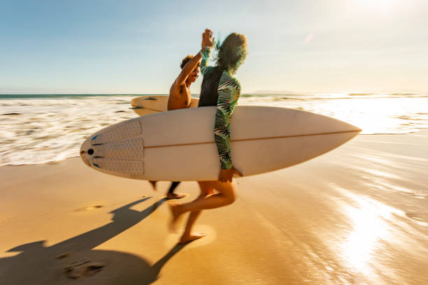istock Running Surfers Giving a High Five 1140036399