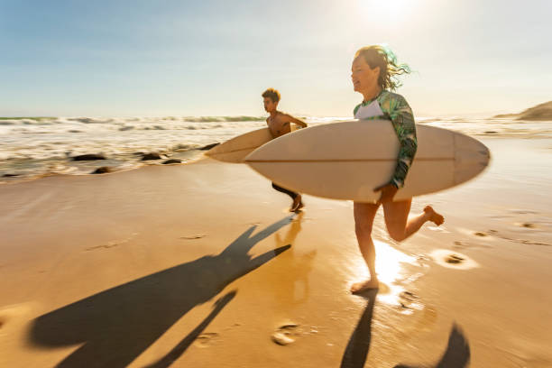 istock Surfers Running on the Beach With Their Surfboards 1140036411