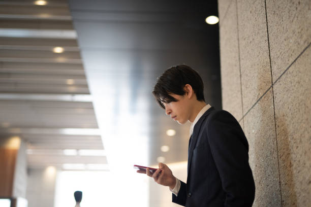 istock Young businessman watching smart phone on street 1140051154