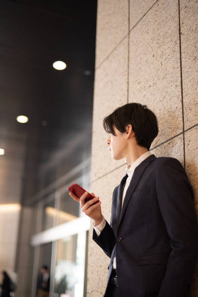 istock Young businessman watching smart phone on street 1140051169