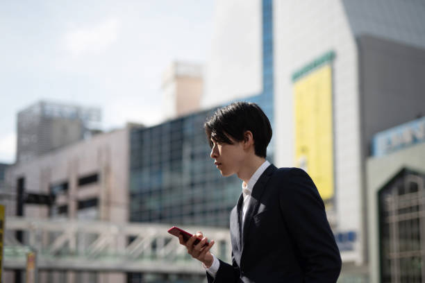 istock Young businessman watching smart phone on street 1140052054