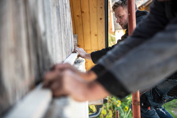 istock Construction workers installing wooden planks on house facade 1140059759