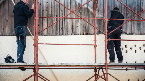 istock Construction workers installing wooden planks on house facade 1140059766