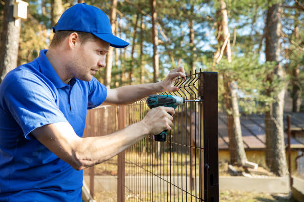 istock fencing services - worker installing welded metal mesh fence 1140064387