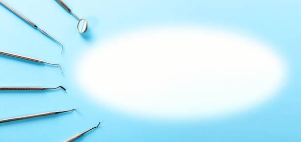 istock Dentist tools. Professional steel dental instruments with a mirror on light blue background with free space. Dental health and teethcare concept. 1140065691