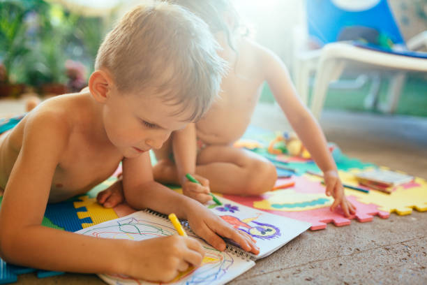 istock Little boy and girl drawing with crayons 1140066162