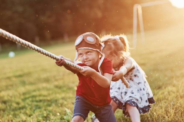 It's all about teamwork. This is tug of war with dad on beautiful grass of sunny warm day It's all about teamwork. This is tug of war with dad on beautiful grass of sunny warm day. pulling stock pictures, royalty-free photos & images