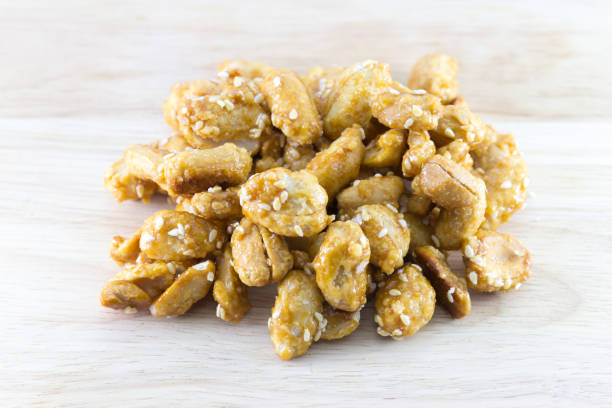 istock Peanuts in caramel with sesame seeds on wood desk 1140068524
